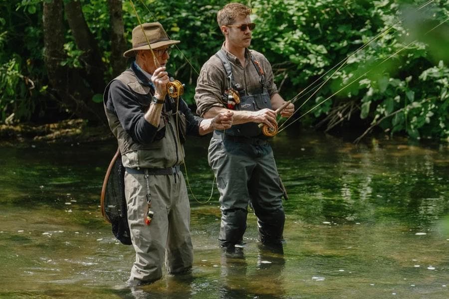 Two anglers casting fly rods in a shallow river